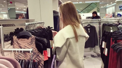 A cute girl sucks a dick and takes cum in her mouth, in a fitting room, in a shopping center