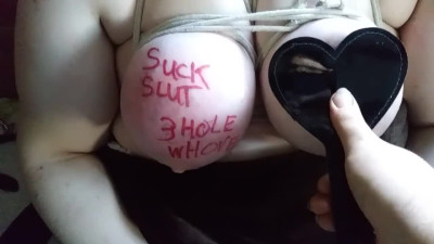 Slave with large breasts humiliated and beat with spiked paddle
