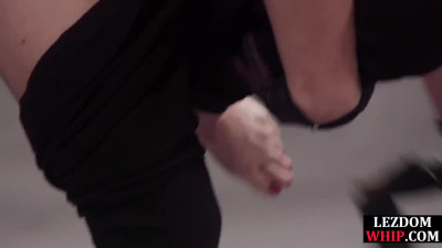 Submissive BDSM lez licks pussy of domina through table hole